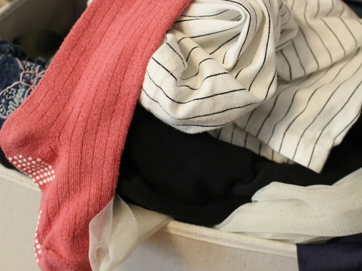 収納から服が溢れるイメージ